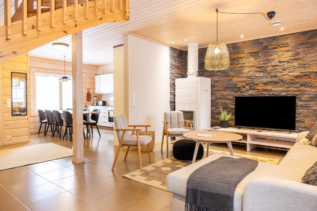a living room with a couch and a tv and a table at Villa Pyry in Vuokatti