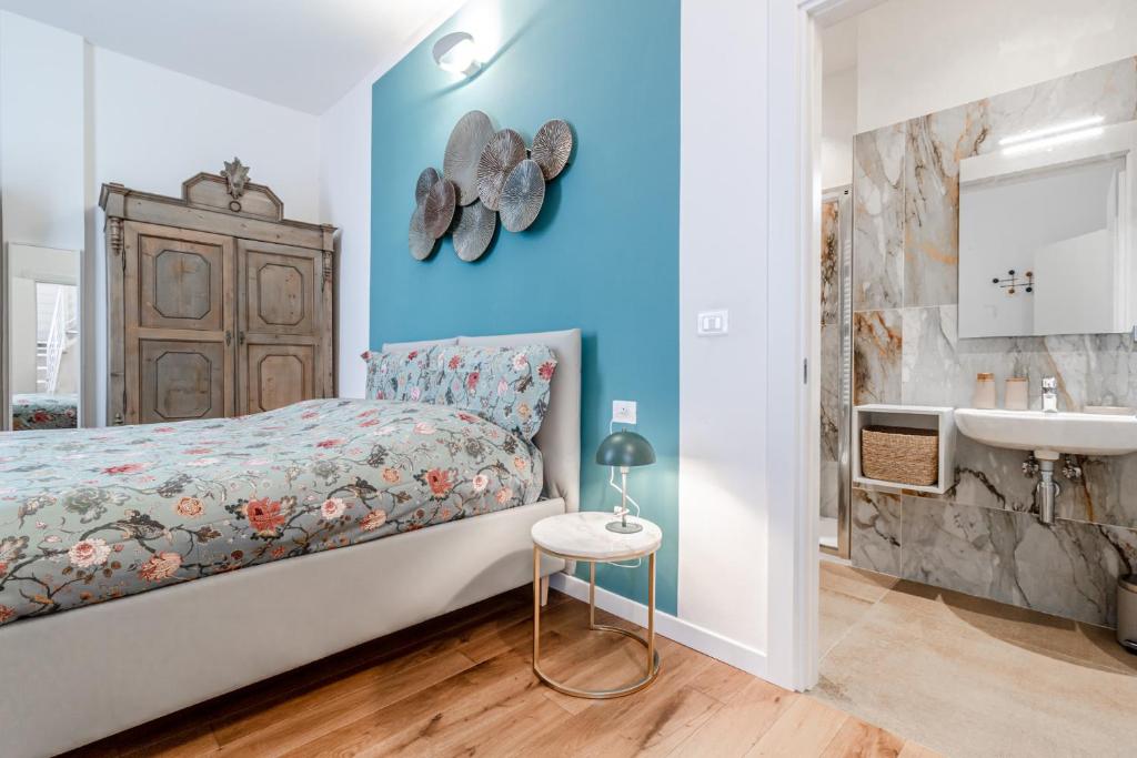 a bedroom with a bed and a bathroom with a sink at Casa Fossato in Bologna