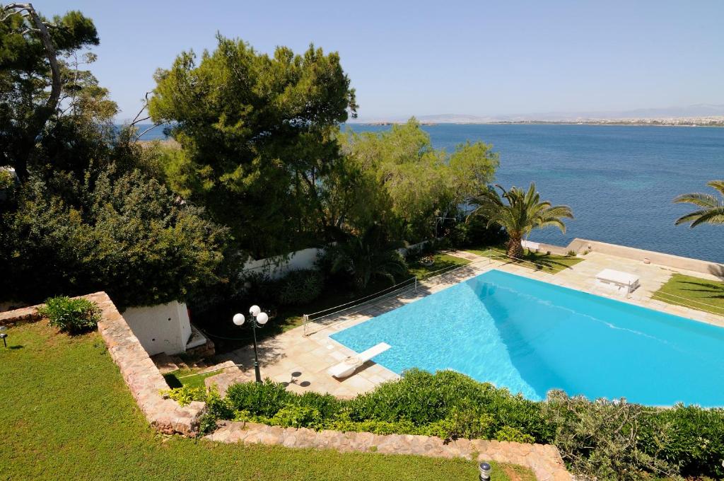 an outdoor swimming pool with a view of the ocean at Kavouri Flat in Athens