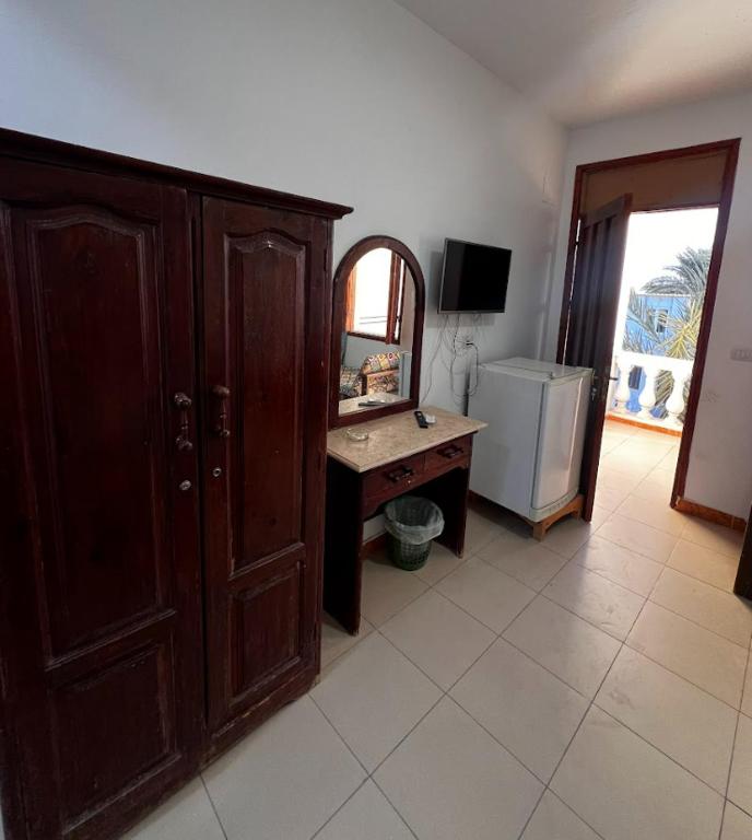 a room with a wooden cabinet and a desk with a mirror at Octopus Hotel in Dahab
