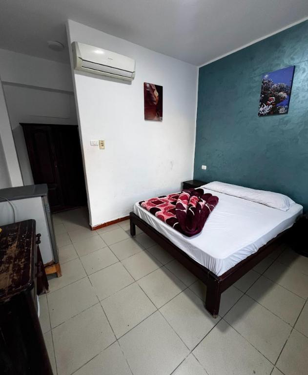 a bedroom with a bed with a red blanket on it at Octopus Hotel in Dahab