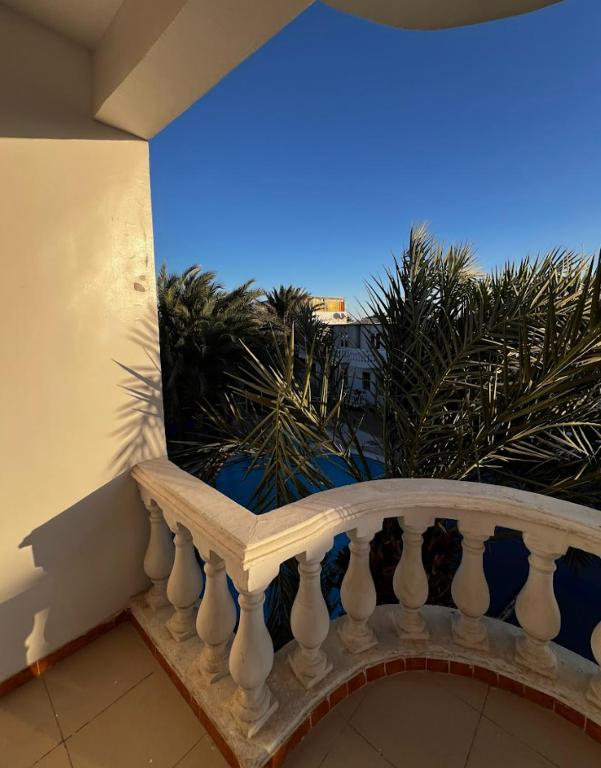 a balcony with a white railing and palm trees at Octopus Hotel in Dahab