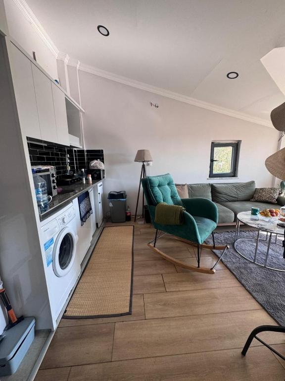 a living room with a couch and a washing machine at ByLotos in Side