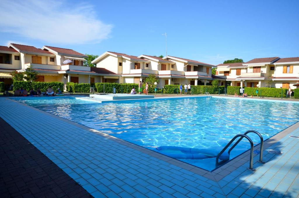 basen przed kilkoma budynkami mieszkalnymi w obiekcie Villaggio Loriana w Bibione
