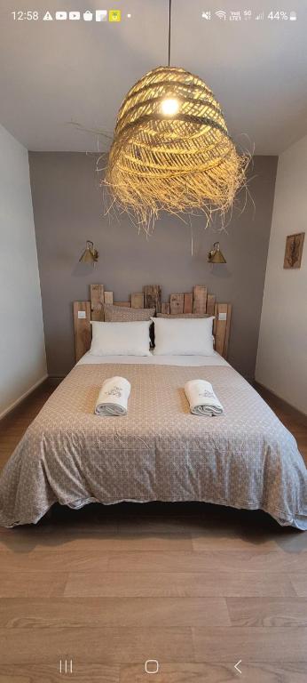 - une chambre avec un grand lit et un grand lustre dans l'établissement appartement cosy et confortable, à Tulle