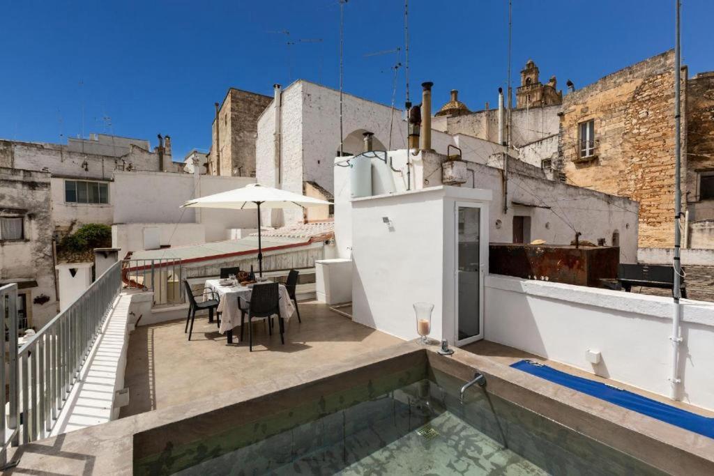 a balcony with a table and an umbrella on a building at Suite Princess Sophie in Ostuni
