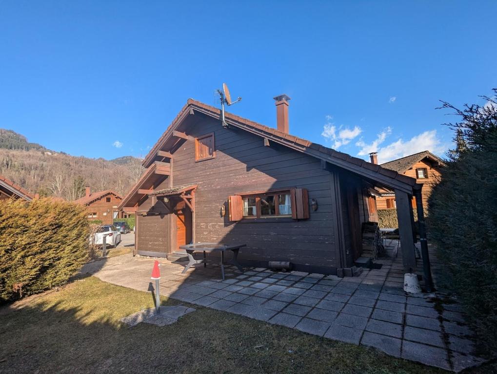 une maison avec un toit en gambrel et une terrasse dans l'établissement Chalet avec jardin, au pied du skibus, proche de Samoens, à Verchaix