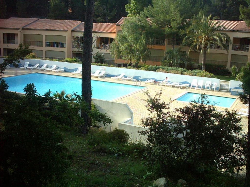 une grande piscine avec des chaises longues dans un complexe dans l'établissement vacances au bord de mer, à Sanary-sur-Mer