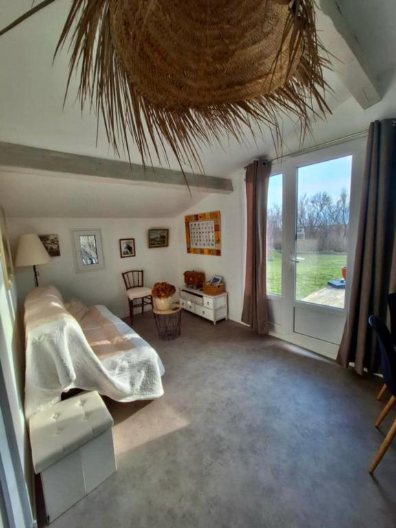 une chambre avec un lit et une grande fenêtre dans l'établissement De l'eau et des oiseaux !, à Saintes-Maries-de-la-Mer