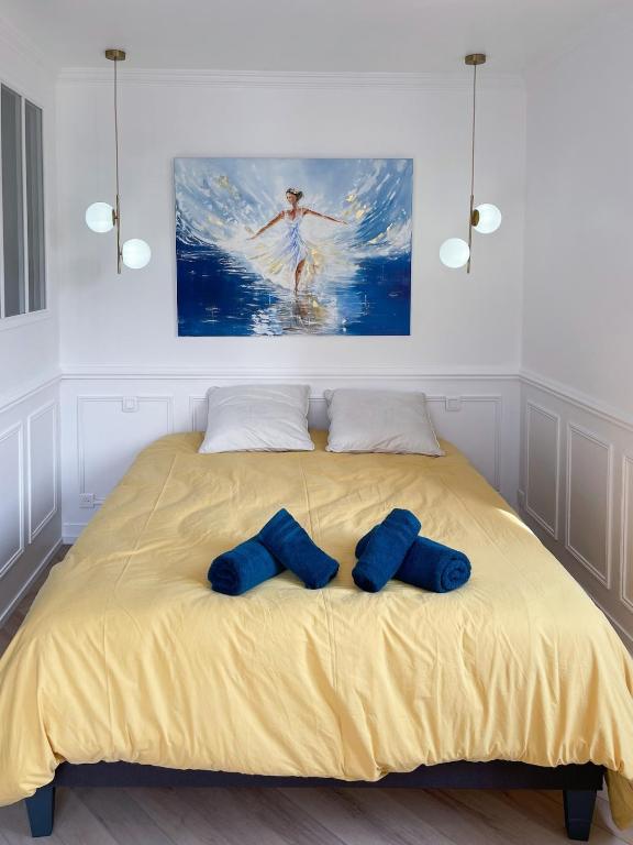 un lit avec deux oreillers bleus dessus dans l'établissement L'Écrin Dieppois - Proche Plage & Parking Gratuit, à Dieppe