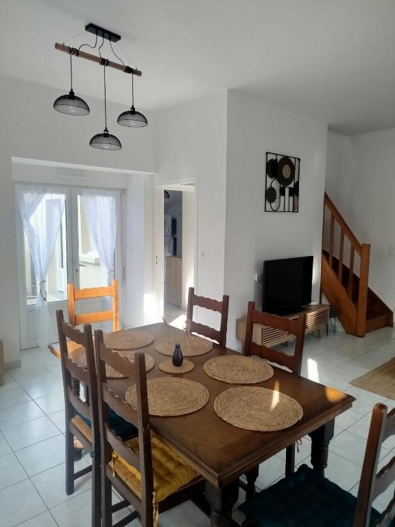 une salle à manger avec une table et des chaises en bois dans l'établissement Au refuge de la baie, à Pontorson