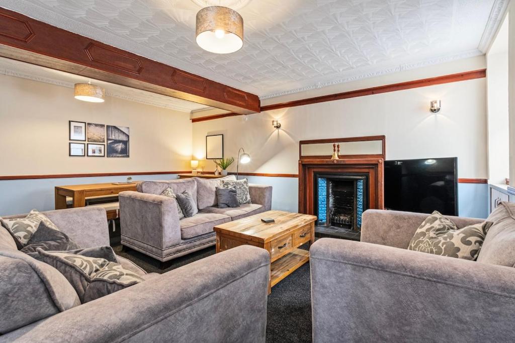 a living room with couches and a fireplace at Keith - Spacious 4 bed house in Keith