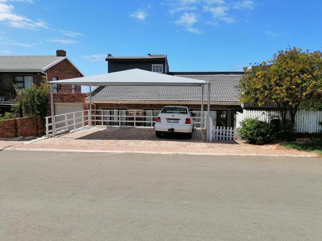 a white car parked in front of a house at Macaw Villa in Mossel Bay