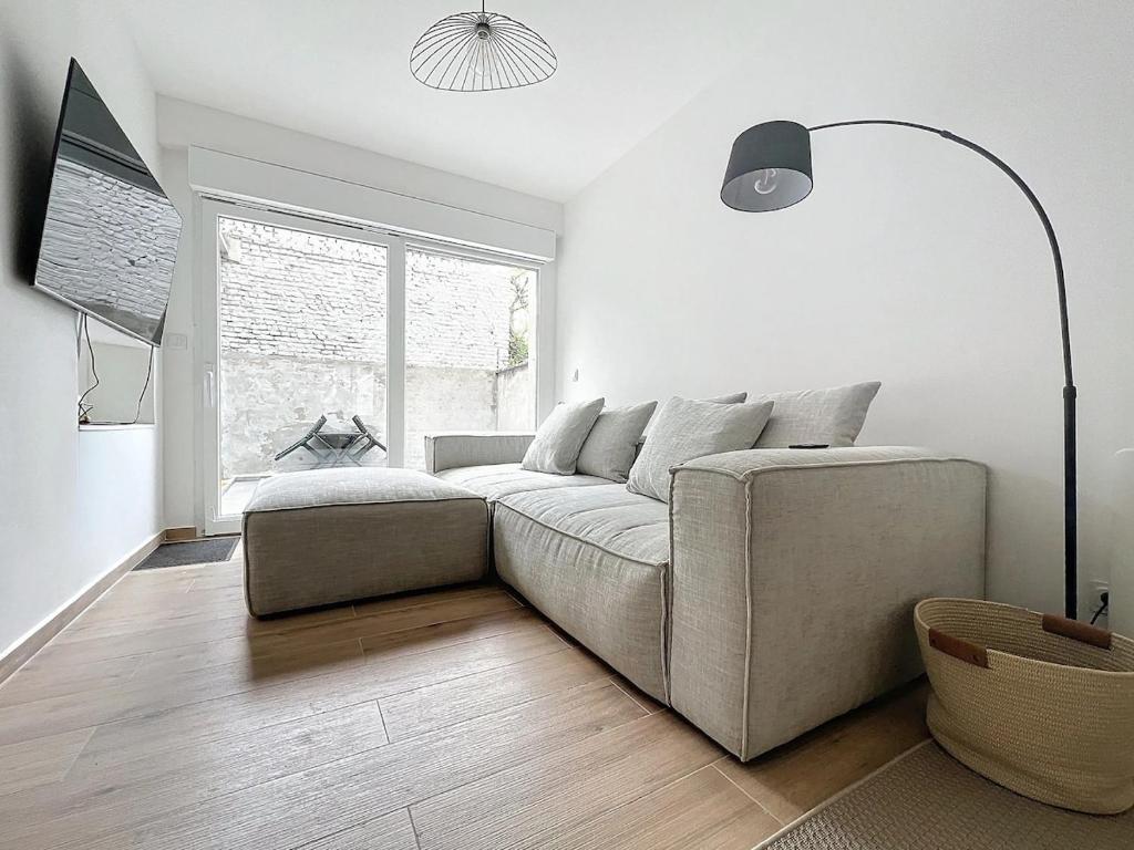 un salon avec un canapé et une fenêtre dans l'établissement Cosy T2 à proximité de la Gare 15 minutes de Lille, à Armentières