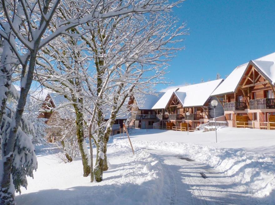un lodge dans la neige avec des arbres enneigés dans l'établissement Appartement duplex 8 pers à Super-Besse avec wifi et piscine chauffée, à Besse-et-Saint-Anastaise