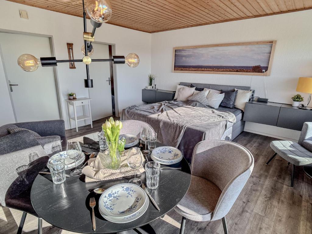 a living room with a table and a bed at FeWo Friesenperle - Schillig in Horumersiel