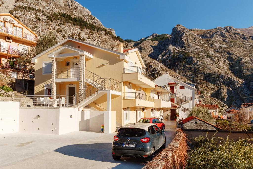a car parked in a parking lot in front of a house at Apartments Blue Sea in Kotor