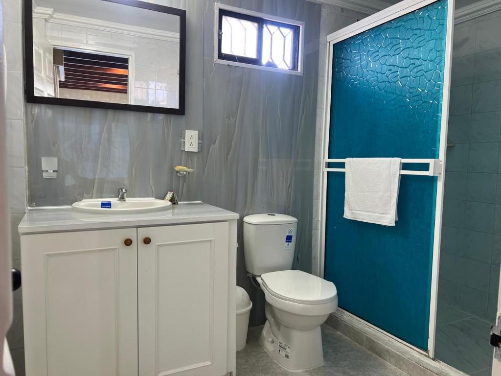 a bathroom with a toilet and a sink and a blue door at HNH Hotel Luxury Experiencia Vip in San Andrés