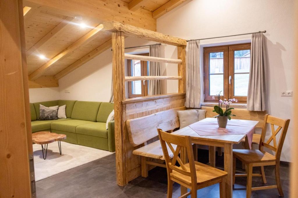 ビショフスヴィーゼンにあるFerienwohnung Hirnsberglehenのリビングルーム(テーブル、緑のソファ付)