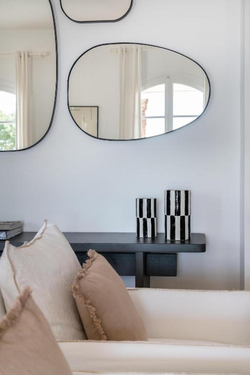 a living room with a couch and two mirrors at Villa Seascape, Beachfront Living in the Greek Riviera Porto Heli in Porto Heli