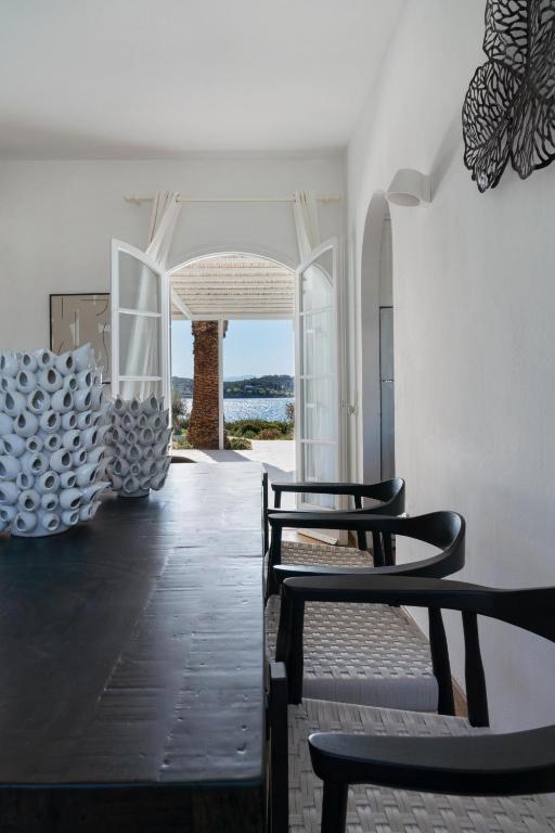 a room with three chairs and a hallway with a view at Villa Seascape, Beachfront Living in the Greek Riviera Porto Heli in Porto Heli