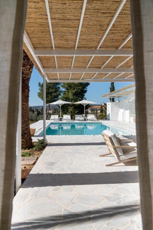 a view of a swimming pool with a pergola at Villa Seascape, Beachfront Living in the Greek Riviera Porto Heli in Porto Heli