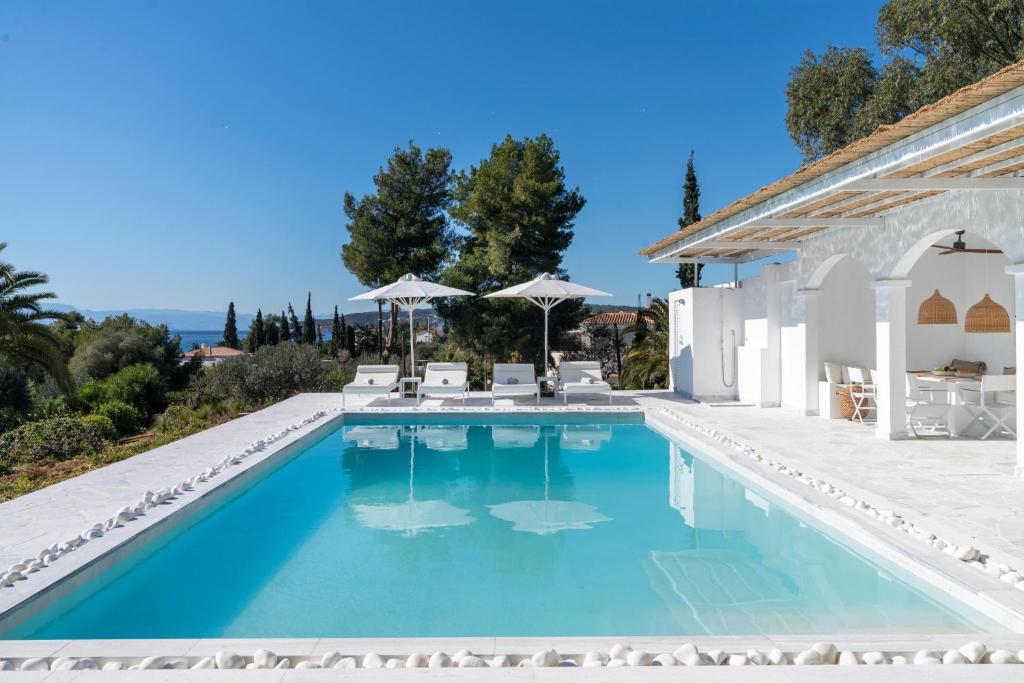 a swimming pool in a villa with blue water at Villa Seascape, Beachfront Living in the Greek Riviera Porto Heli in Porto Heli