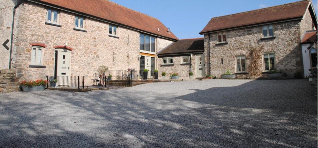 a large brick building with a driveway in front of it at Little Howle Farm Barn in Ross on Wye