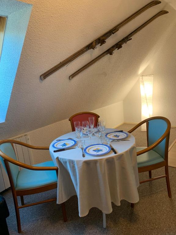 une table avec un chiffon de table blanc et deux chaises dans l'établissement Studio des Ô Gentianes - 7 Laux, à Le Haut-Breda