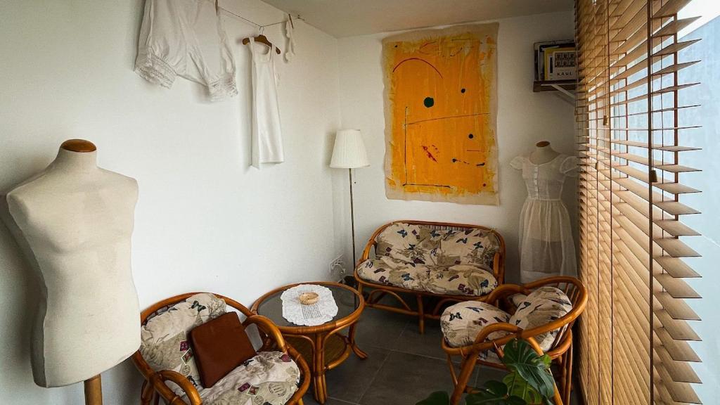 une chambre avec des chaises, une table et un mannequin dans l'établissement La Blanchisserie, à Mazé