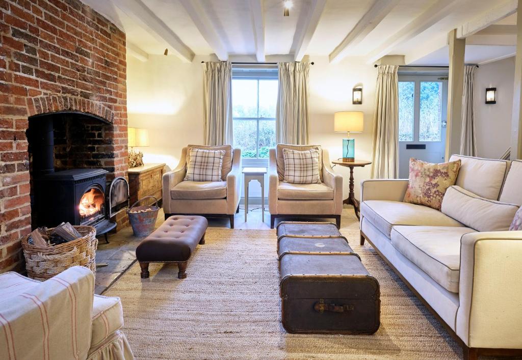 un soggiorno con divano e camino di Grints Cottage a Burnham Thorpe