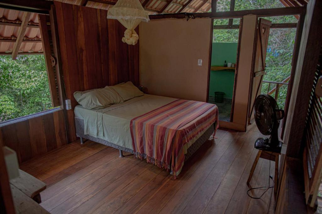 a bedroom with a bed in a room with windows at Suíte Curuaçu in Santarém