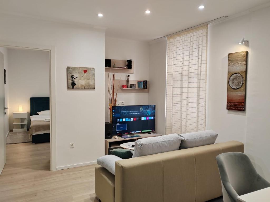 a living room with a couch and a television at Mare et Silva Apartment Dubrovnik in Dubrovnik