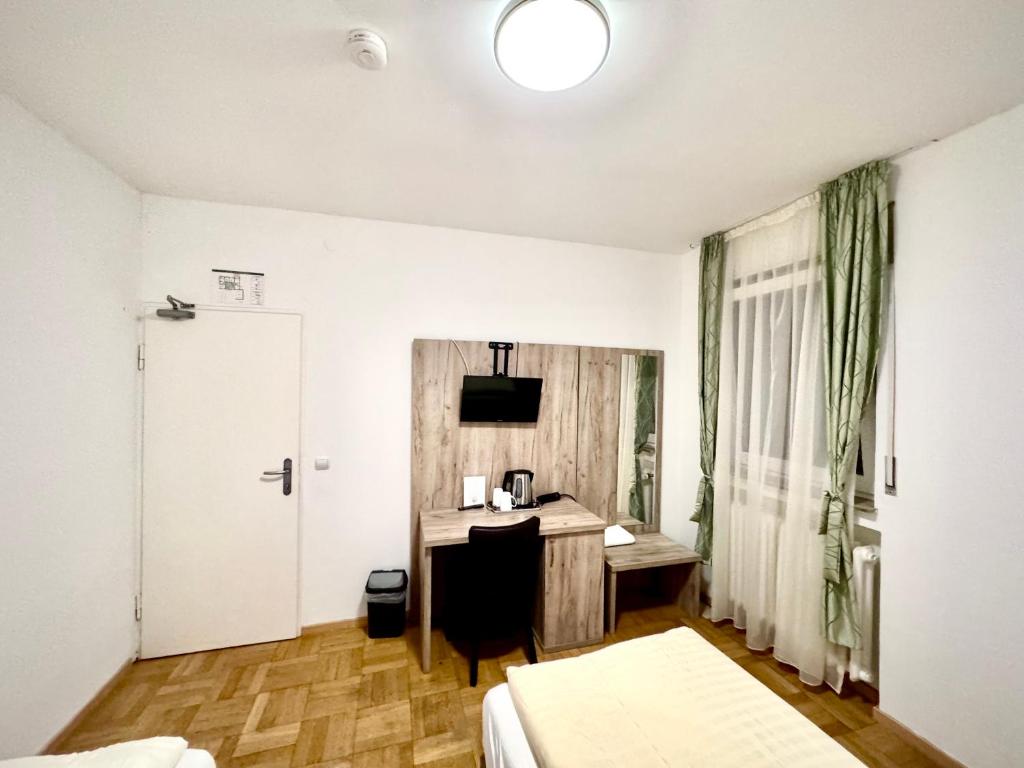 a hotel room with a desk and a bed at Hotel Soad in Salach