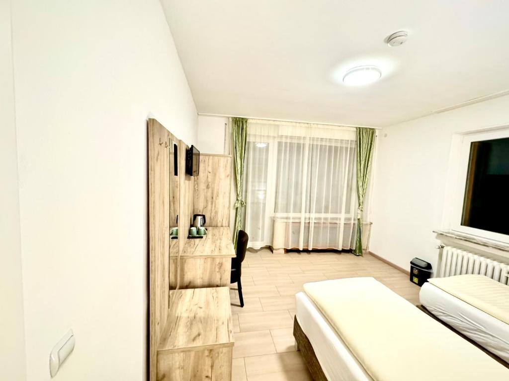 a bedroom with a bed and a chair in a room at Hotel Soad in Salach
