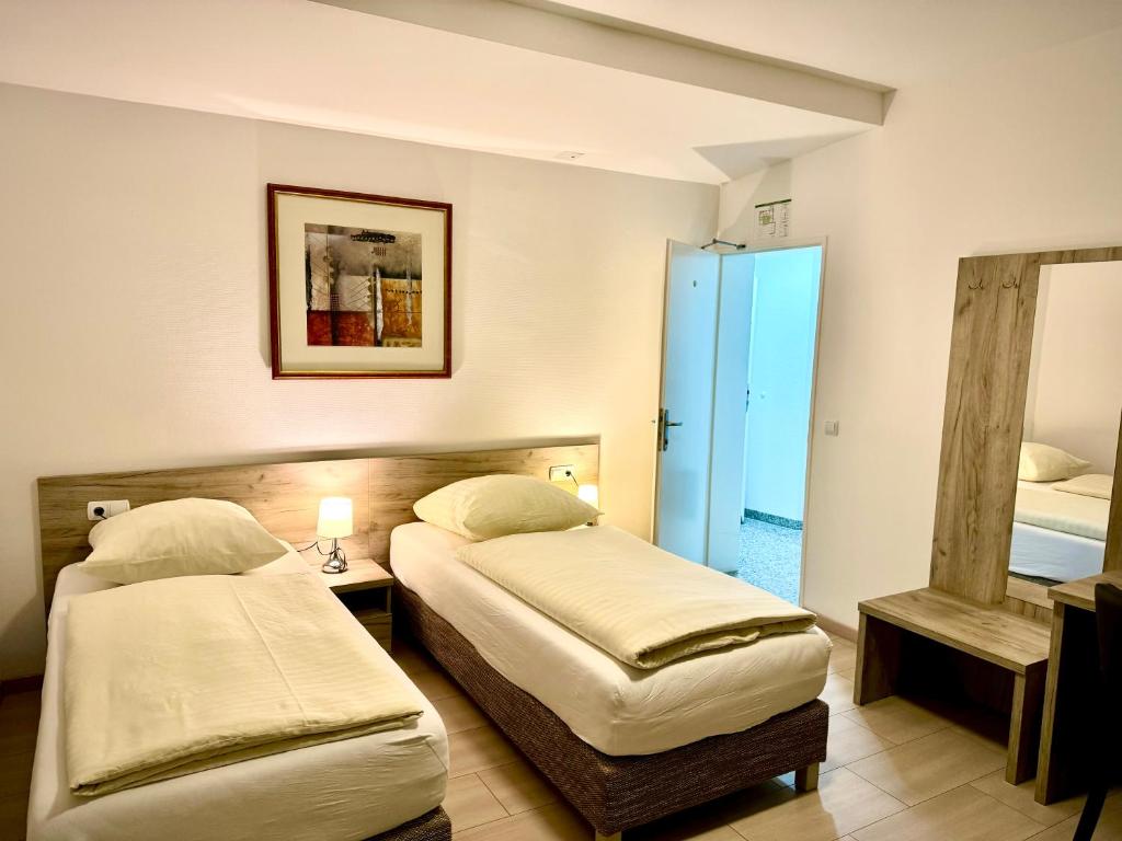 a hotel room with two beds and a mirror at Hotel Soad in Salach