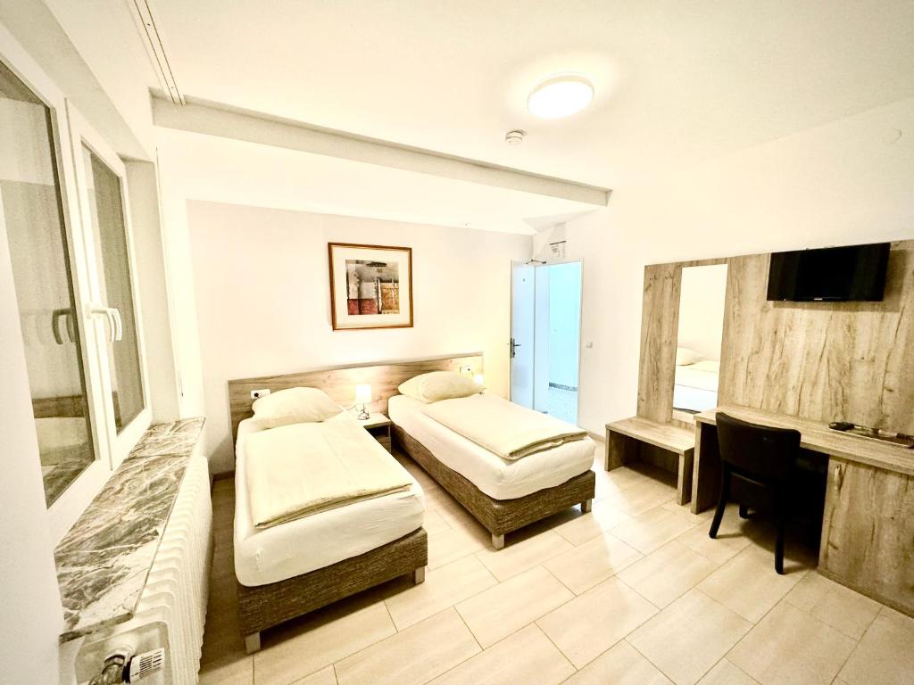 a hotel room with two beds and a television at Hotel Soad in Salach