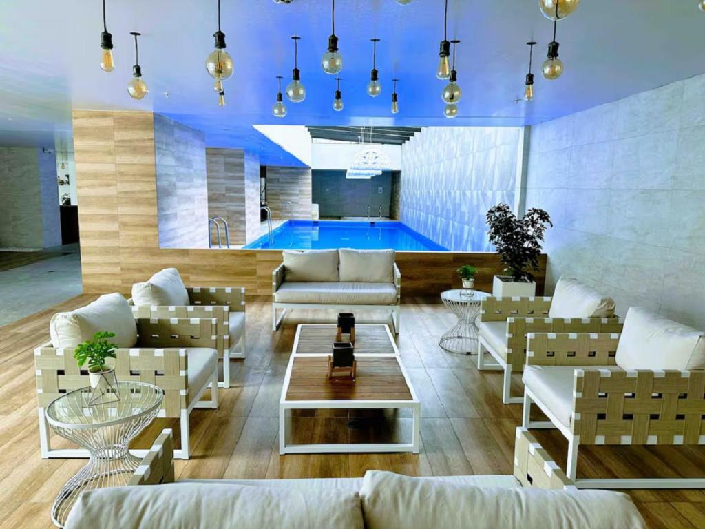 een woonkamer met banken en een zwembad bij ONE Luxury Views Suite Terrace La Carolina Park Heated Pool & Jacuzzi in Quito