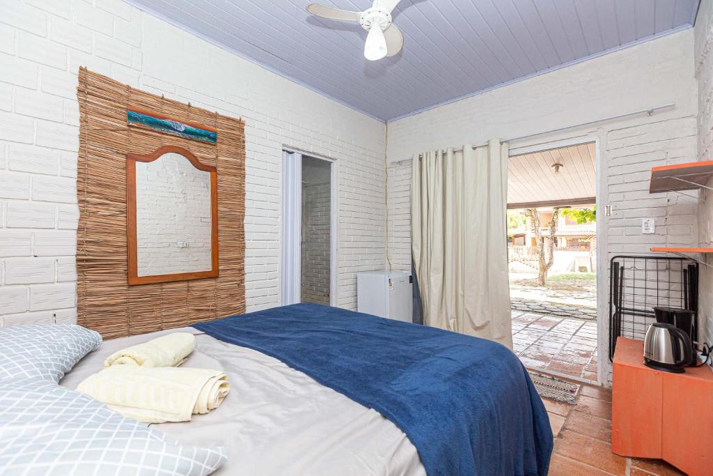 a bedroom with a bed with a blue comforter at Memora Guesthouse Pontal do Paraná - Suíte a duas quadras da Praia e perto da Ilha do Mel in Pontal do Paraná