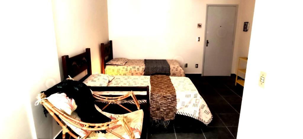 a bedroom with two beds and a rocking chair at Economical Hosting Downtown - Hospedagem econômica no centro de Campinas in Campinas
