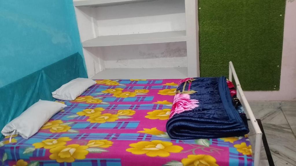 a bed with a colorful blanket on it in a room at Kumbh Home Stay in Jhūsi