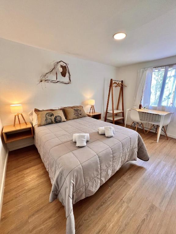 a bedroom with a large bed with towels on it at Apart Las Carretas in El Calafate