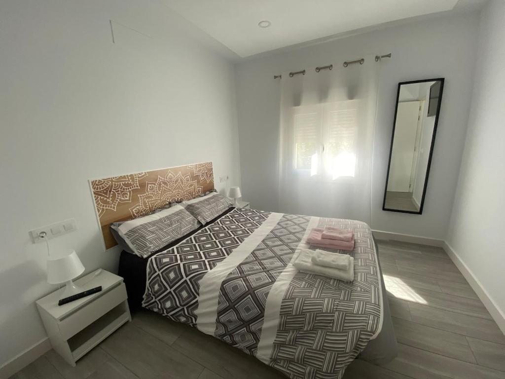 une chambre avec un grand lit et un miroir dans l'établissement Family Apartment, à Arcos de la Frontera