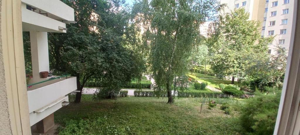 une vue d'un jardin depuis la fenêtre d'un immeuble dans l'établissement Cichy i przyjemny pokój na Muranowie, à Varsovie