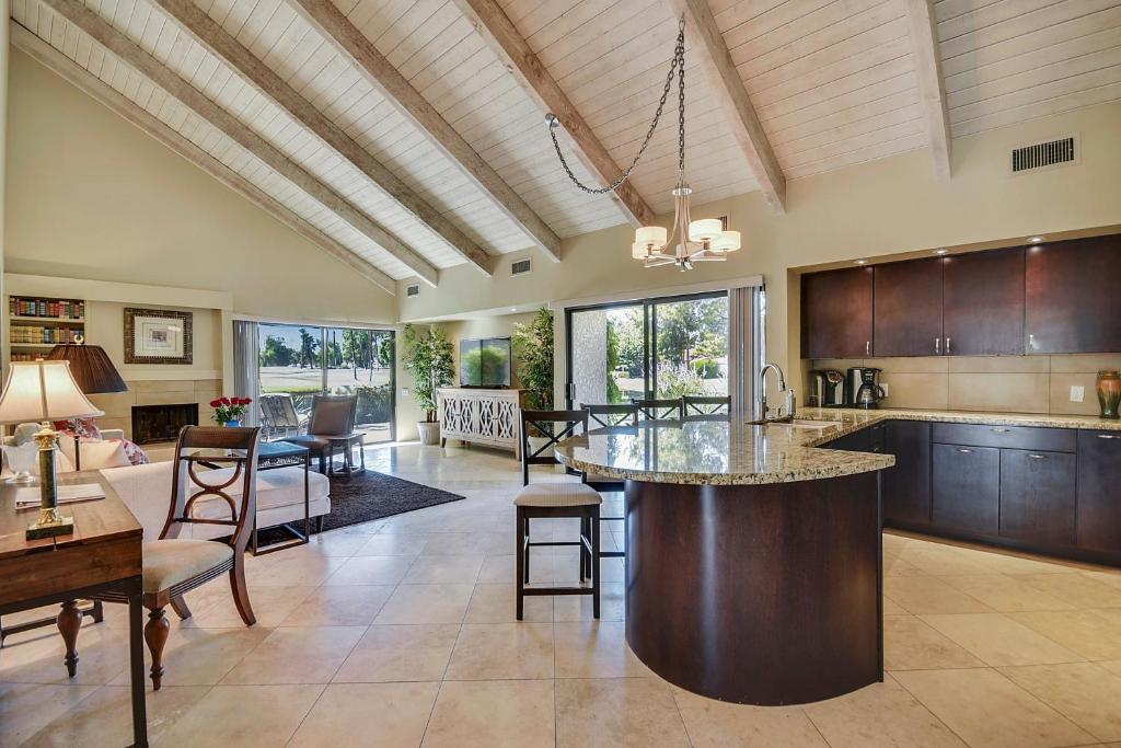a kitchen and living room with a large island at Elegant Lakeside Villa in Rancho Mirage