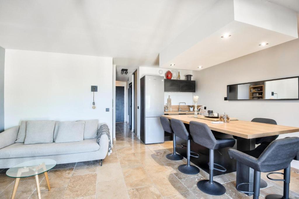 une cuisine et un salon avec une table et des chaises dans l'établissement Village Pont Royal en Provence - maeva Home - Appartement moderne et climatisé 2 pièces 4 personnes - Prestige - super Home MAE-0581, à Mallemort