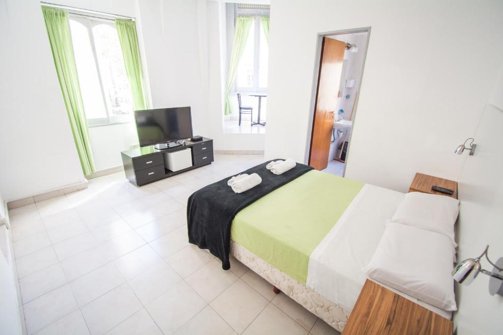 a bedroom with a bed and a tv in it at Hotel Dos Mundos in Buenos Aires