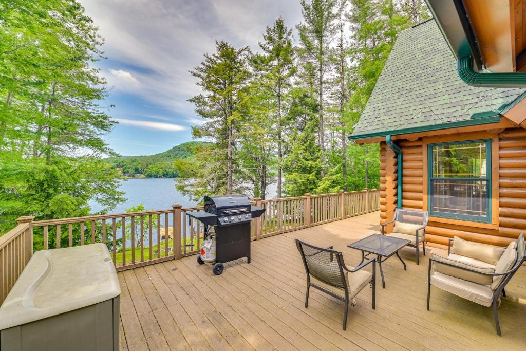 una casa con griglia su una terrazza con lago di Lakefront Corinth Log Home Private Dock, Fire Pit a Lake Luzerne