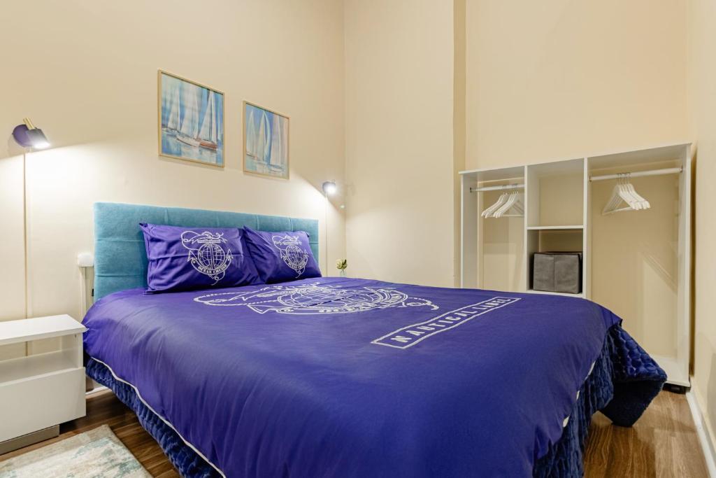 ein Schlafzimmer mit einem lila Bett in einem Zimmer in der Unterkunft Seixal Yachting Bay Vintage in Seixal