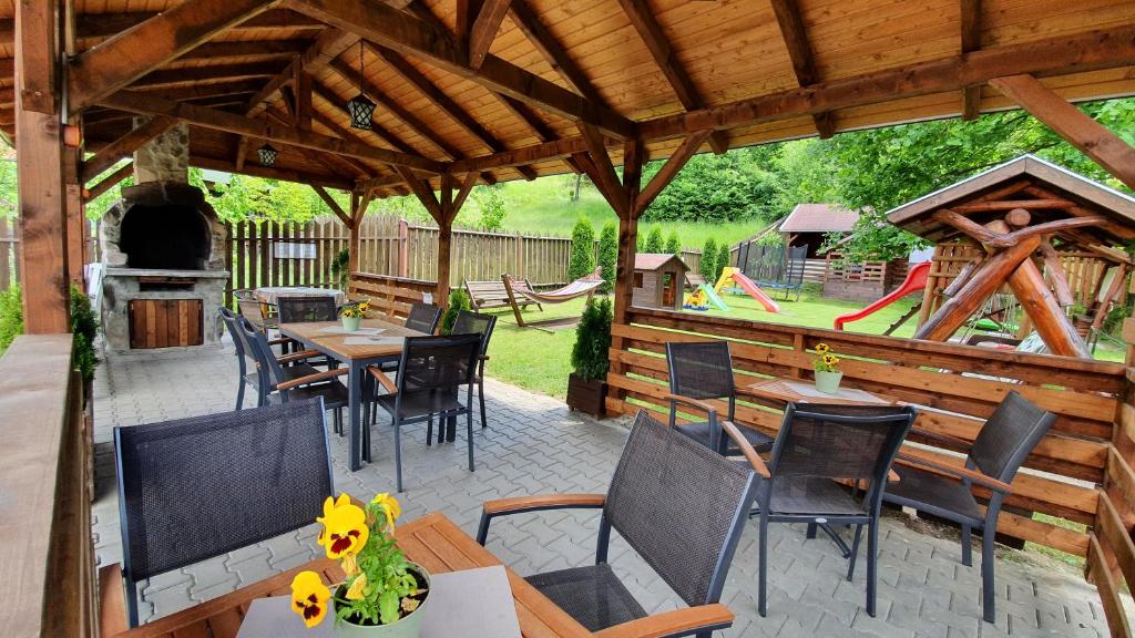 an outdoor patio with tables and chairs and a playground at Pensiunea Bogada in Praid